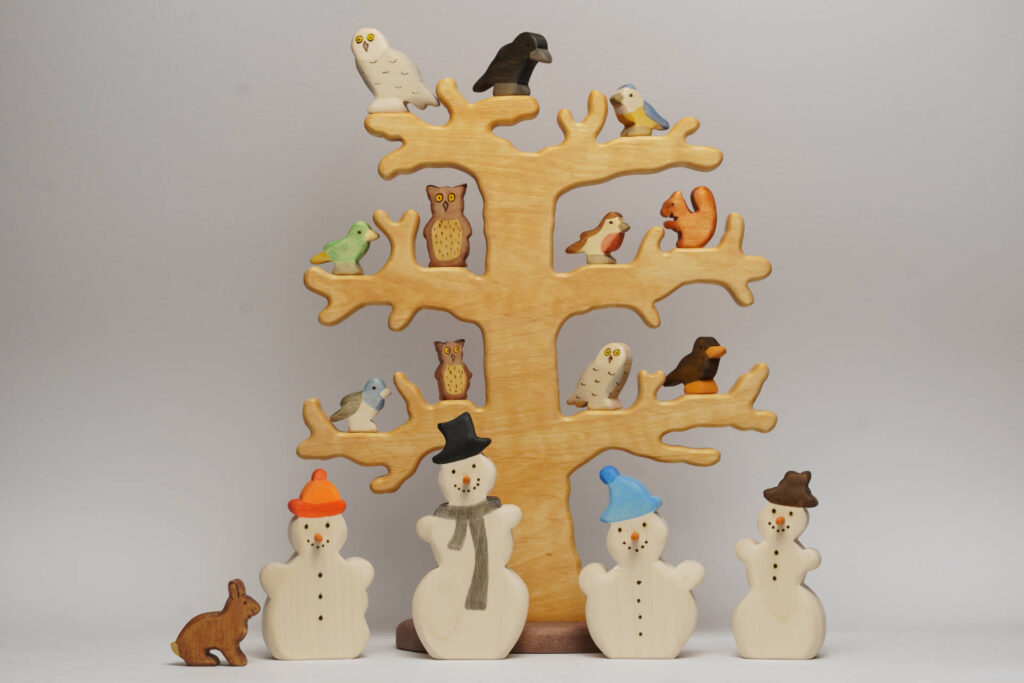 Winterbaum mit Schneemann und Voegeln