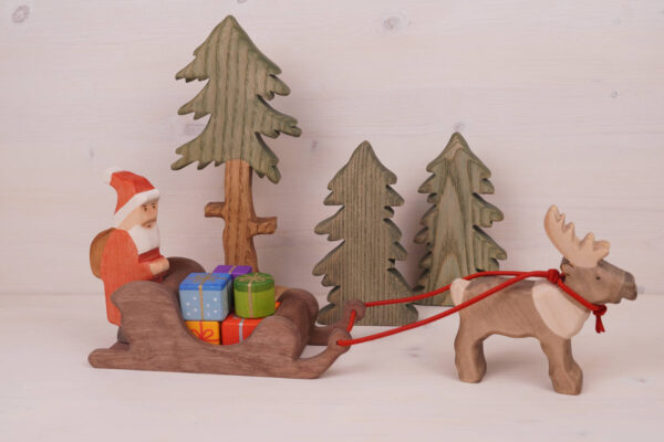 Weihnachtsmann mit Rentierschlitten Tannen und Päckchen